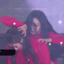 a woman in a red dress is standing next to another woman in a red dress