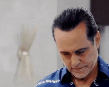 a man in a blue shirt is looking down