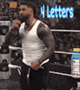 a man in a white tank top is holding a microphone in a boxing ring .