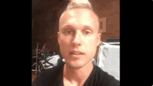 a young man in a black shirt is taking a selfie
