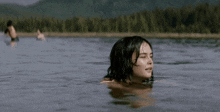 a woman in a white tank top is swimming in the water