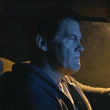 a man in a blue jacket is sitting in a car