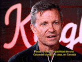 a man is standing in front of a sign that says k on it