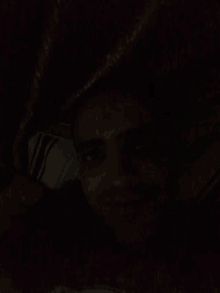 a close up of a person 's face in the dark with their eyes closed