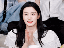 a woman in a white shirt is clapping her hands in front of an ulabby logo