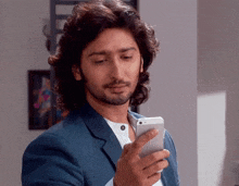 a man in a suit is looking at his phone
