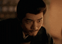 a man with a beard is looking at the camera in the dark