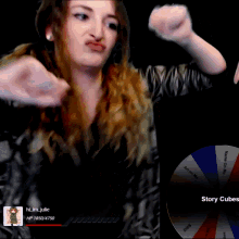 a woman is making a face in front of a wheel that says story cubes