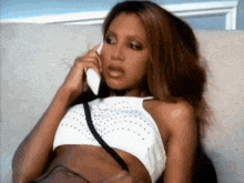 a woman in a crop top is talking on a phone