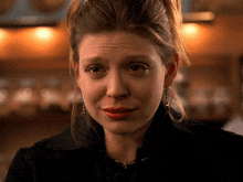 a woman with a sad look on her face is wearing earrings