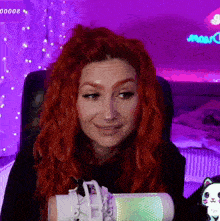 a woman with red hair is sitting in front of a microphone with a purple background and a purple sign that says 00000