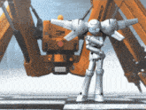 a robot is standing in front of an orange object that says project on it