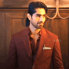 a man in a red suit is standing in front of a wall