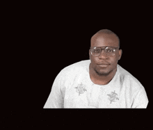 a man wearing glasses and a white shirt is making a face .