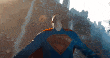 a man in a superman costume is flying through the air with his arms outstretched