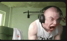 a man wearing headphones and goggles is making a funny face while playing a video game .
