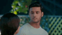 a man in a white shirt is looking at a woman