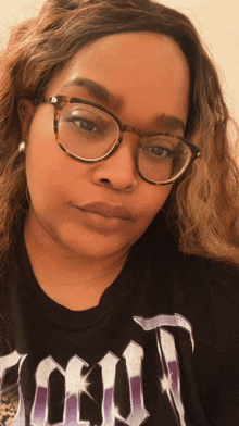 a woman wearing glasses and a t-shirt with the word tokyo on it