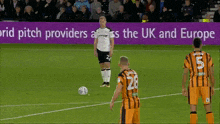 a soccer game is being played in front of a sign that says ' pitch providers across the uk and europe '