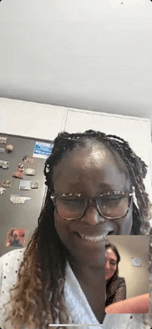 a woman wearing glasses is smiling while talking to another woman on a video call