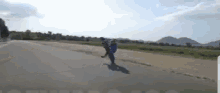a person with a backpack is walking down a road .