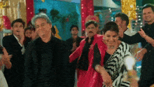 a group of people are dancing together in a room with a lot of lights .