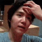 a man is scratching his forehead with his hand .