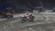 a red monster truck is driving on a dirt road