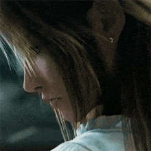 a close up of a woman 's face with a white shirt on