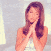 a woman with her eyes closed and her hands folded