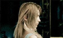a woman with long blonde hair is standing in front of a sign that says ' e ' on it