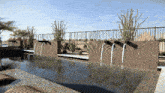 a fence surrounds a swimming pool with water coming out of the wall