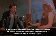 a man in a leather jacket stands next to a woman holding a beer