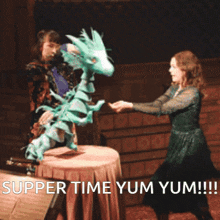 a woman in a green dress is dancing with a puppet that says " super time yum yum "