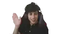 a young man wearing headphones and a black shirt is waving his hand