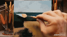 a person is painting a picture of the ocean and the words made in animatica are visible