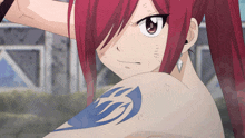 a girl with red hair has a blue tattoo on her shoulder
