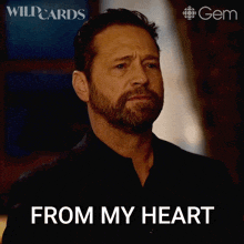 a man with a beard is giving a thanks gesture