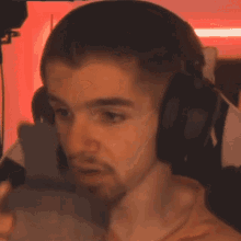 a man wearing headphones is sitting in front of a computer .
