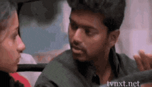 a man is talking to a woman in a car .