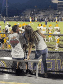 a man and a woman watching a football game with the number 64 on the back of their jersey
