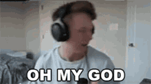 a man wearing headphones is talking into a microphone and saying oh my god .