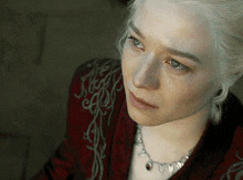 a close up of a woman 's face with a necklace on