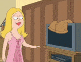 a woman in a pink dress is standing next to a tv