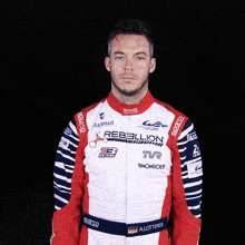 a man in a red and white rebellion racing jacket