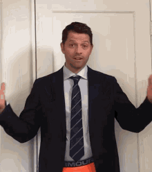 a man in a suit and tie with under armour underwear on his pants