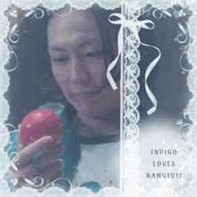 a picture of a man holding a red apple with the words indigo loves namgyu on the bottom