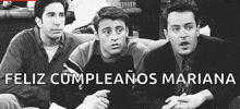 a black and white photo of three men sitting on a couch with the words `` feliz cumpleanos mariana '' in the corner .