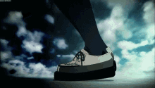 a person is walking on a sidewalk wearing a pair of white shoes .