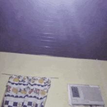 a blurry picture of a room with a purple ceiling and checkered curtains